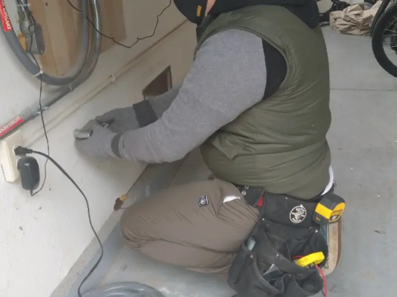 Electrician performing outlet wiring in a Carthage garage